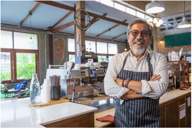 A barista behind the counter of a coffee shop.