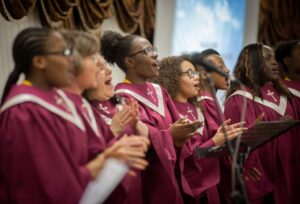 A group of women singing wearing religious choir robes