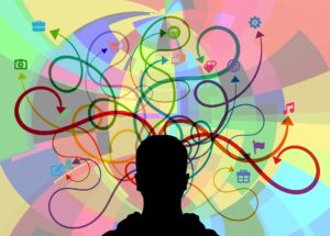silhouette of a person who has a bunch of arrows and tasks coming out of their head representing various thoughts