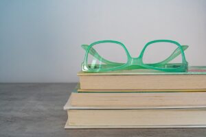 stack of 3 books with a pair of glasses on top