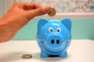 putting a coin into a piggy bank
