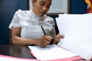 woman signing documents in a folder
