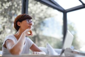 person sitting with a laptop and thinking