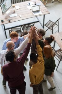 group of office workers in a circle giving a group high five
