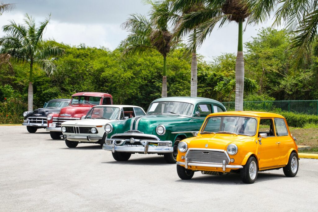 five vintage cars parked in a row