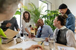 co-workers gathering around a meeting table laughing