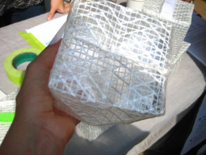 The "Solar Puff," inflatable light. It has white cross-hatching on all sides and when expanded, takes the shape of a cube.