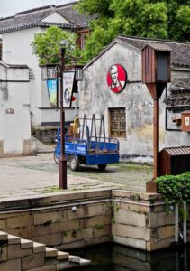 the K F C logo on the outside of a traditional Chinese building in China