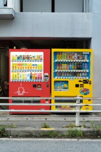 two vending machines selling drinks located on a sidewalk in Japan
