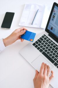 person with a credit card uses a laptop to make a purchase online