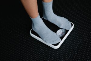 Feet stepping onto a scale in kilograms