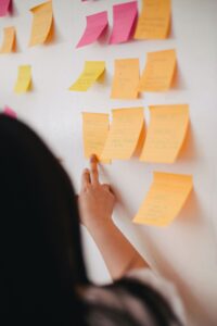 A woman looking at sticky notes on a wall