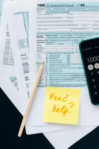 Tax paperwork with a sticky note that says "Need help?"