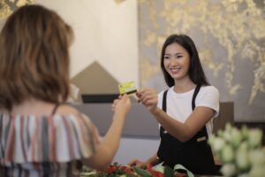 A woman handing a credit card back to a customer