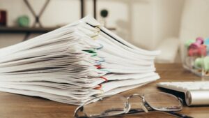A stack of documents held together with paper clips