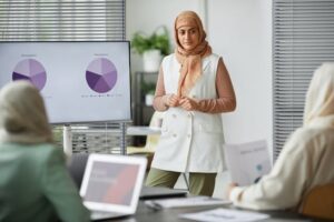 Person giving a presentation using pie charts displayed on a screen