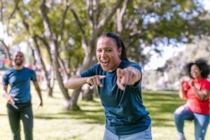Enthusiastic employee at a team building event laughing and pointing at the photographer