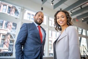 A man and woman both dressed in suits at an office